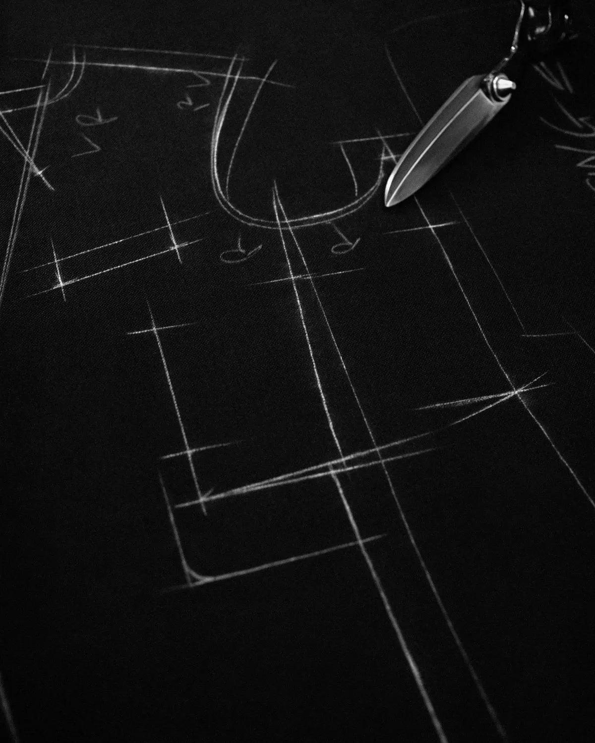 Tailor's chalk marks drawn across dark cloth