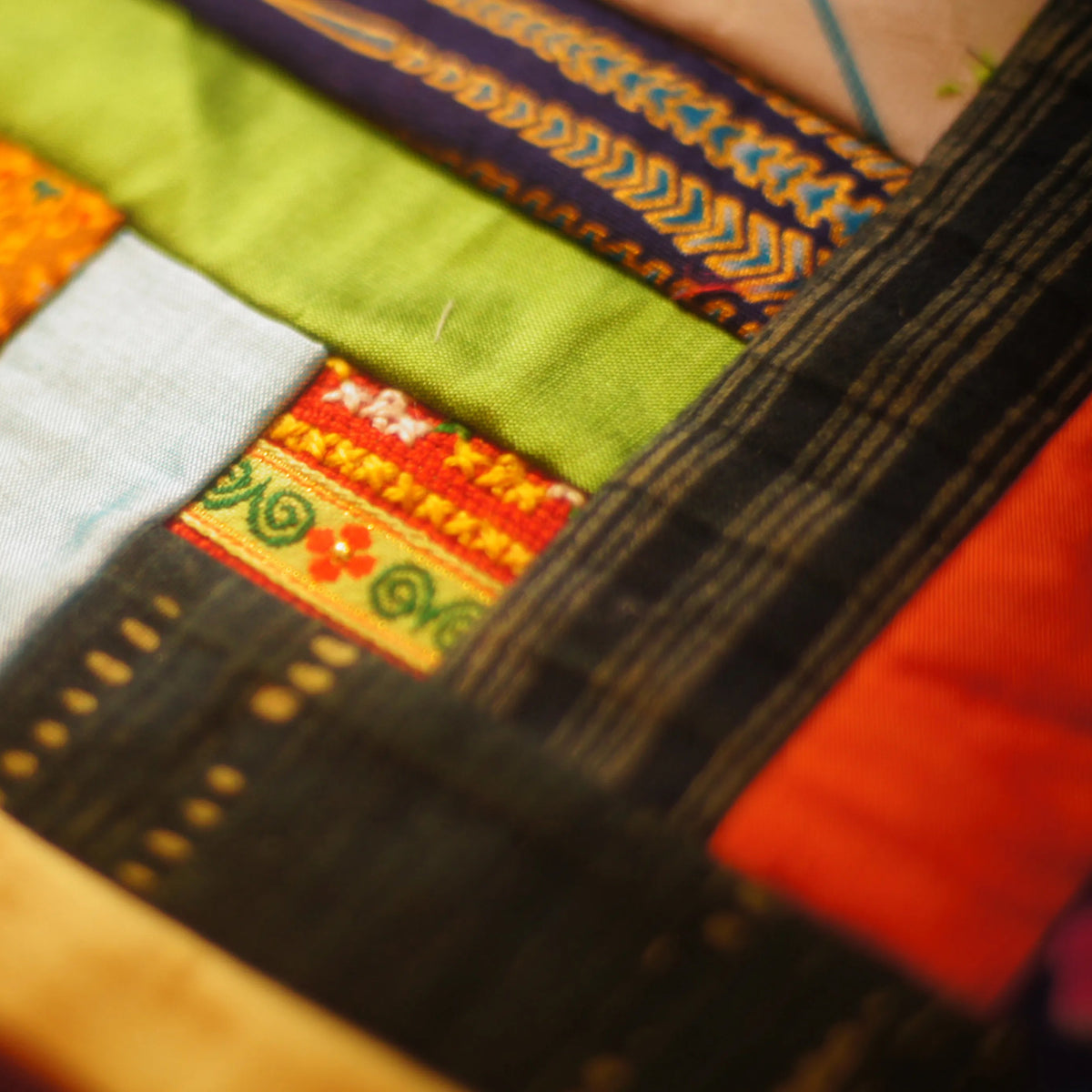 Bands of woven hill-tribe trim stitched to cloth, in close-up